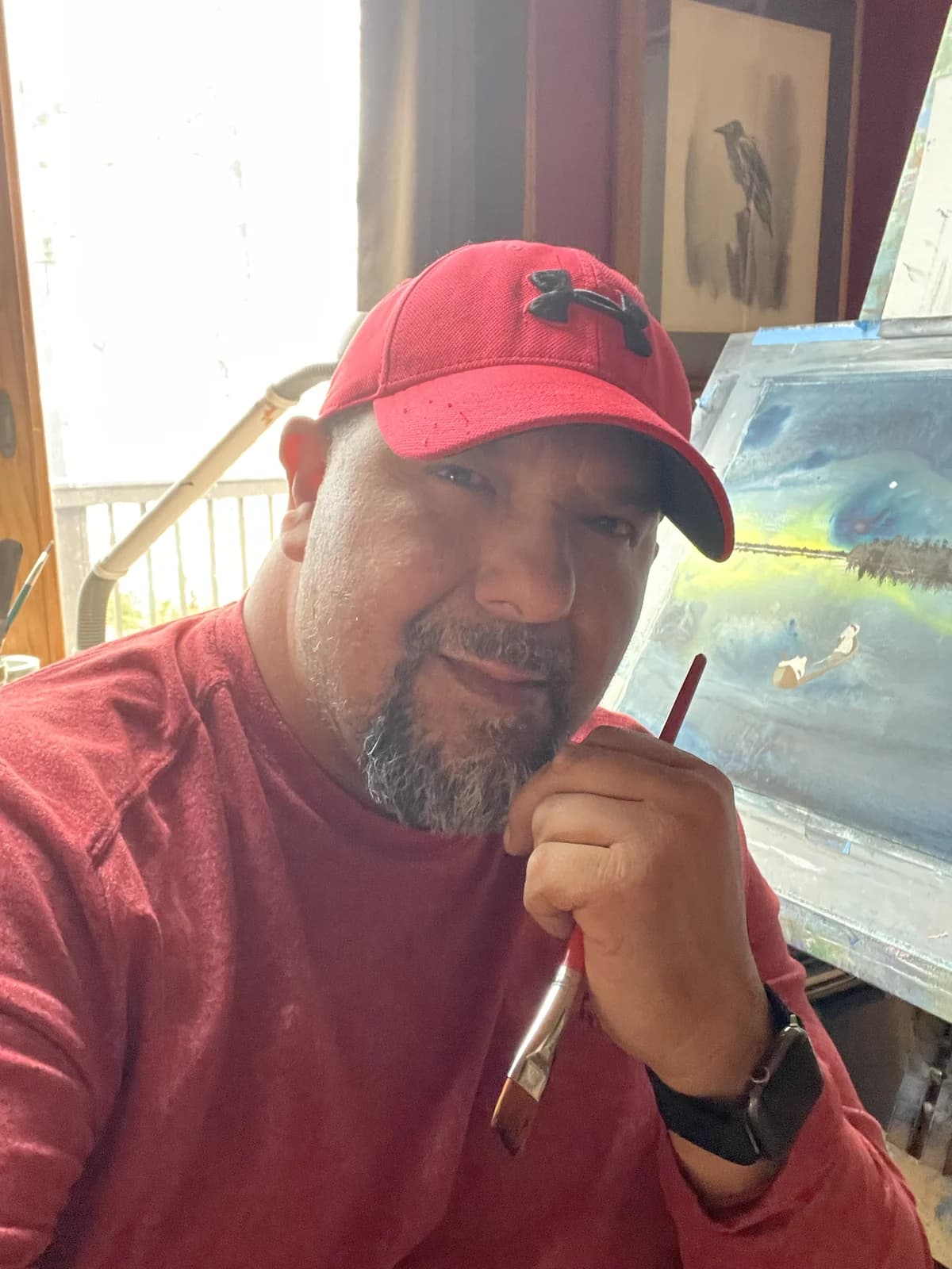 Clarence Rising Sun holding a paintbrush in his studio